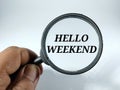 Text HELLL WEEKEND on a magnifying glass isolated on a white background. Royalty Free Stock Photo