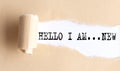 The text HELLO, I AM NEW appears on torn paper on white background Royalty Free Stock Photo