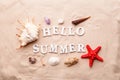 Text Hello Summer from white letters and sea shells and starfish on sand Royalty Free Stock Photo