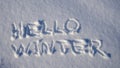 Text HELLO WINTER, written on fresh white snow with shining icy crystals in cold sunny day. Natural winter Christmas and New year Royalty Free Stock Photo