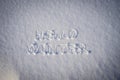 Text HELLO WINTER, written on fresh white snow with shining icy crystals in cold sunny day. Natural winter Christmas and New year Royalty Free Stock Photo