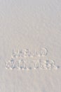 Text HELLO WINTER, written on fresh white snow with shining icy crystals in cold sunny day. Natural winter Christmas and New year Royalty Free Stock Photo