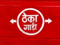 Text in Hindi on a red background on a transport vehicle meaning it is available on rent
