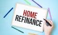 Text Home refinance on a notebook surrounded by colored felt-tip pens, business concept idea Royalty Free Stock Photo
