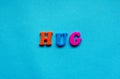 text hug rom plastic colored letters on blue paper background.