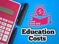 Text and icon of Education Costs on blue background with pen and calculator. Education and finance concept. Royalty Free Stock Photo