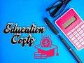 Text and icon of Education Costs, pen, glasses and calculator. Education and finance concept. Royalty Free Stock Photo