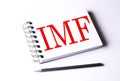 Text IMF on notebook on the white background, business