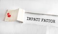 The text IMPACT FACTOR appearing behind torn yellow paper Royalty Free Stock Photo