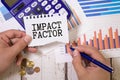 Text IMPACT FACTOR on a crafting notebook on a wooden background. Business concept Royalty Free Stock Photo