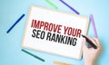 Text Improve Your Seo Ranking on a notebook surrounded by colored felt-tip pens, business concept idea Royalty Free Stock Photo