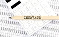 Text INNOVATE on wooden pencil on the calculator with chart Royalty Free Stock Photo