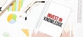 Text Invest In Knowledge on white notepad, glasses, graphs and diagrams Royalty Free Stock Photo