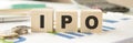 Text IPO on wood cube and gold pem lay on chart Royalty Free Stock Photo