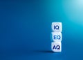 Text IQ,EQ and AQ on white blocks stack on blue background with copy space.