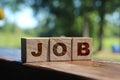 Text JOB on wooden cubes on table outdoors in nature. Freelance career business concept