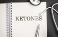 Text KETONES on a white background with stethoscope. Medical concept