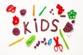 The text kids made from modelling clay of and somemold tools around on the white background. Concept og children art