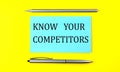 Text KNOW YOUR COMPETITORS on the blue sticker on the yellow background Royalty Free Stock Photo
