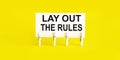 Text LAY OUT THE RULES on white short note paper yellow background Royalty Free Stock Photo