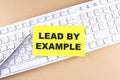 Text LEAD BY EXAMPLE text on a sticky on keyboard, business concept Royalty Free Stock Photo