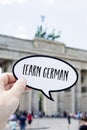 Text learn german in front of the Brandenburg Gate