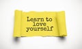 Text Learn to love yourself appearing behind ripped brown paper Royalty Free Stock Photo