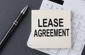 Text LEASE AGREEMENT on the sticker on the calculator, business concept Royalty Free Stock Photo
