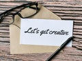 Text lets get creative written on white paper Royalty Free Stock Photo