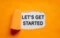 The text `lets get started` appearing behind torn orange paper. Business concept. Copy space Royalty Free Stock Photo