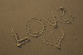 Love written in the sand and a heart drawn in the sand Royalty Free Stock Photo