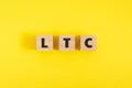 Text LTC Litecoin on wooden cubes on yellow background. Ripple. Crypto currency. Buy and sell.