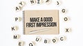Text Make a good first impression on the craft colored notepad with block wood cubes on the white background Royalty Free Stock Photo