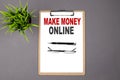 Text MAKE MONEY ONLINE on brown clipboard on the grey background. Business concept Royalty Free Stock Photo