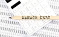 Text MANAGE DEBT on the wooden pencil on the calculator with chart Royalty Free Stock Photo