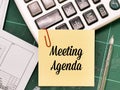 text Meeting Agenda written on yellow paper note with a pen and calculator. Royalty Free Stock Photo