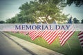 Text Memorial Day on row of lawn American Flags Royalty Free Stock Photo