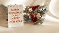 Text MERRY CHRISTMAS AND HAPPY NEW YEAR on a notebook with Christmas tree decorations on a white background . Royalty Free Stock Photo