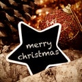 text merry christmas in a star-shaped chalkboard on a rustic background Royalty Free Stock Photo