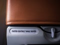 Text message `FASTEN SEAT BELT WHILE SEATED` behind the red airplane seat. Royalty Free Stock Photo