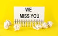 Text WE MISS YOU on the white short note paper yellow background Royalty Free Stock Photo