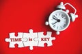 Text on missing jigsaw puzzle with alarm clock background - Time is key. Royalty Free Stock Photo