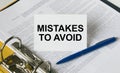 Text Mistakes to Avoid on a white card that is in a folder with documents and a blue pen Royalty Free Stock Photo