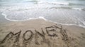 text MONEY on the sand and wave that is erasing the word symbol