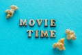 Text `Movie Time` and popcorn on blue background.