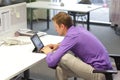 Text neck - man in slouching position working with tablet at desk