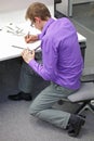 Text neck - man in slouching position writing on paper with pen at desk