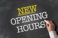 Text NEW OPENING HOURS written on chalkboard