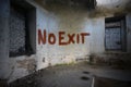Text no exit on the dirty old wall in an abandoned ruined house
