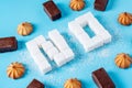 Text No is lined with sugar cubes with sweets and cookies. Harm to the health of sweet and rejection of sucrose